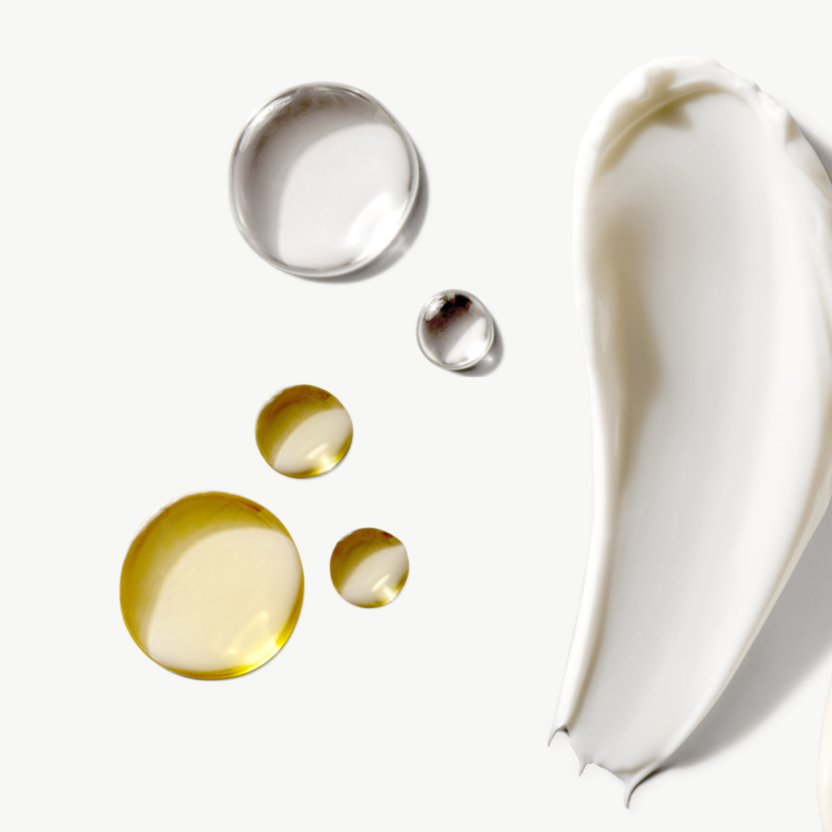 Skincare textures shown as oil droplets and a smooth cream swatch on white background.