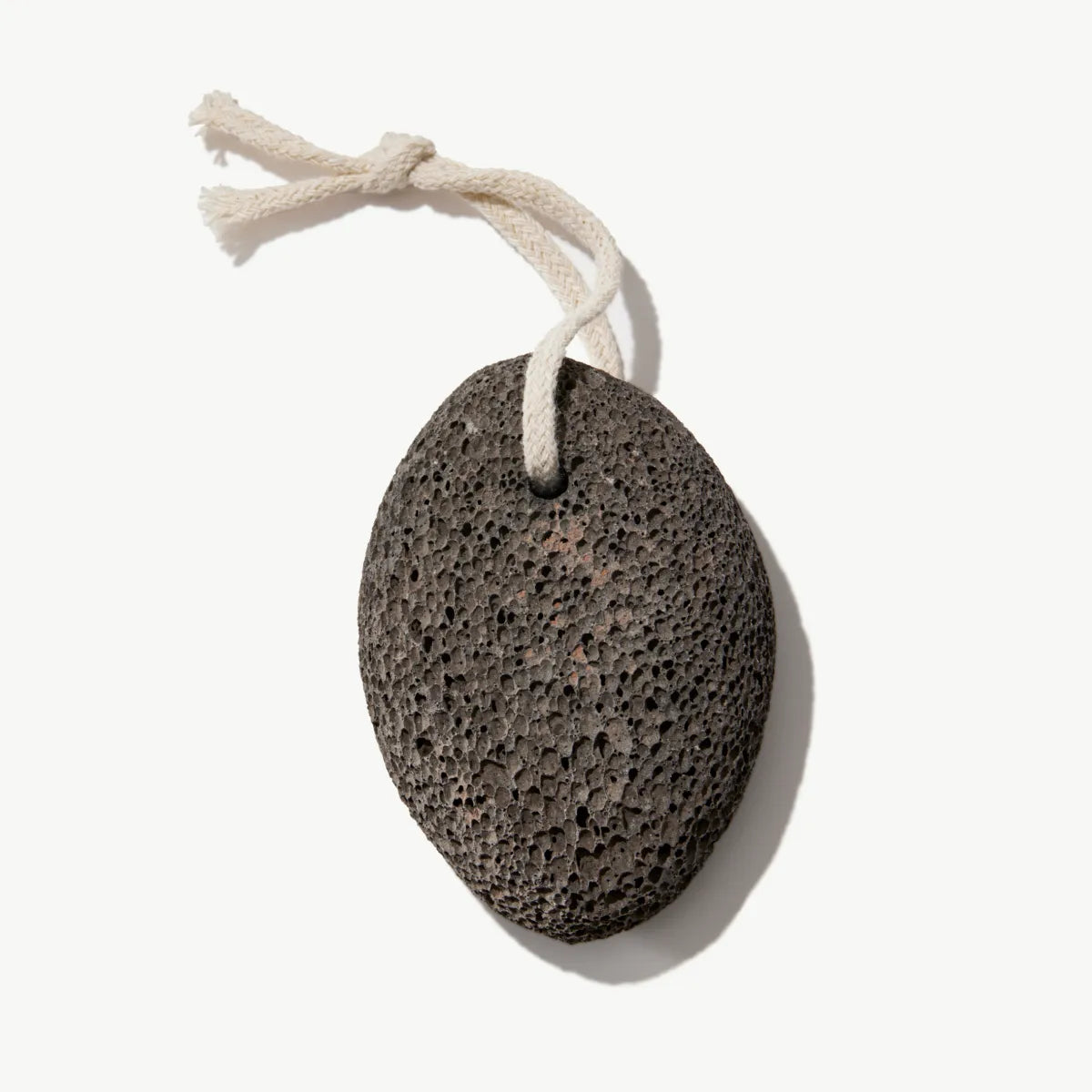 Dark natural pumice stone with hanging cord displayed on a white background