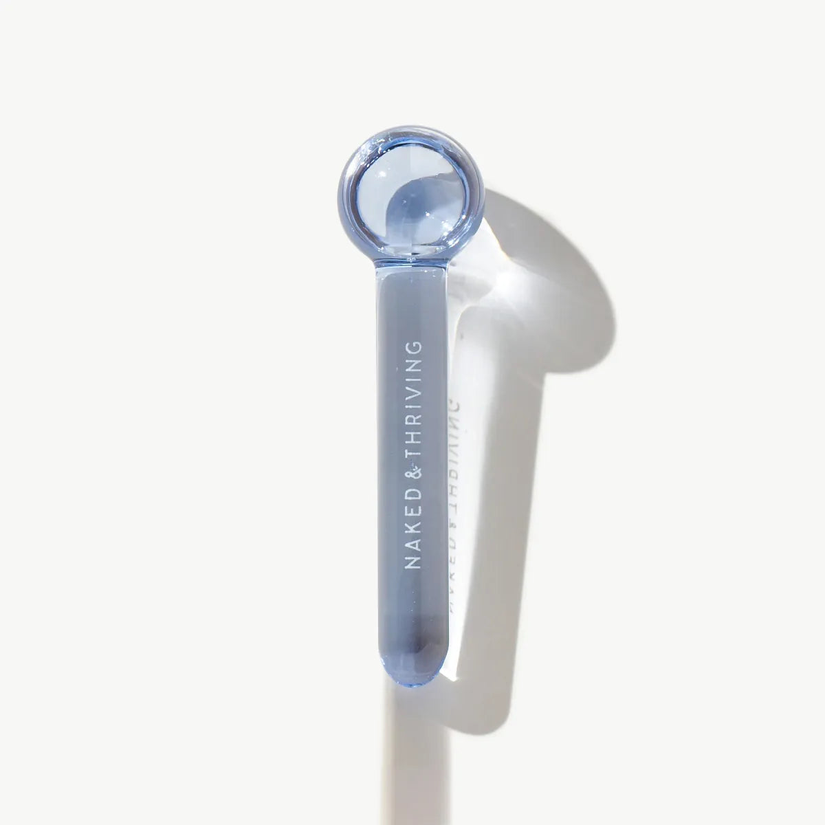 Cooling de-puff globe facial massage tool on white background