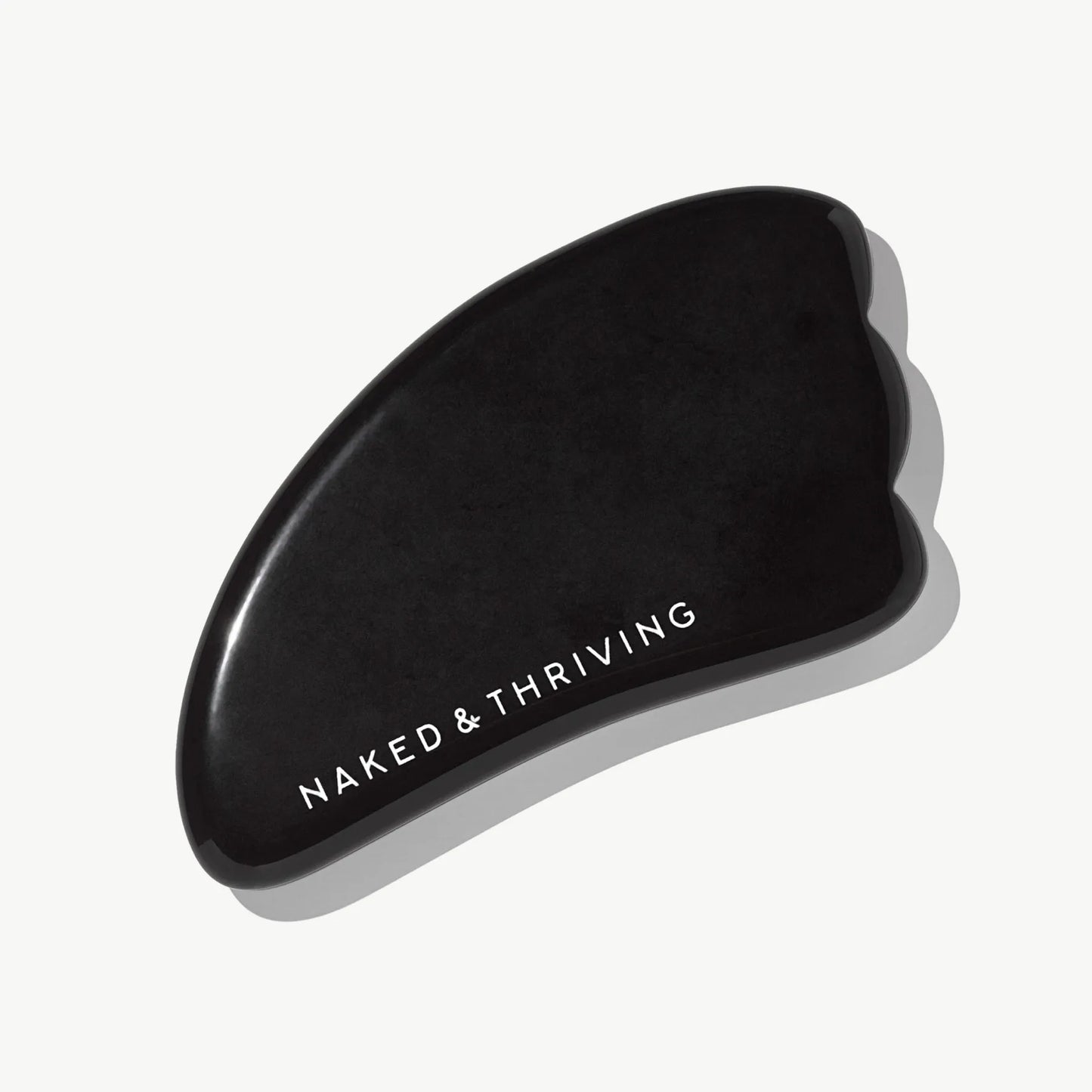 Polished black gua sha stone engraved with brand name