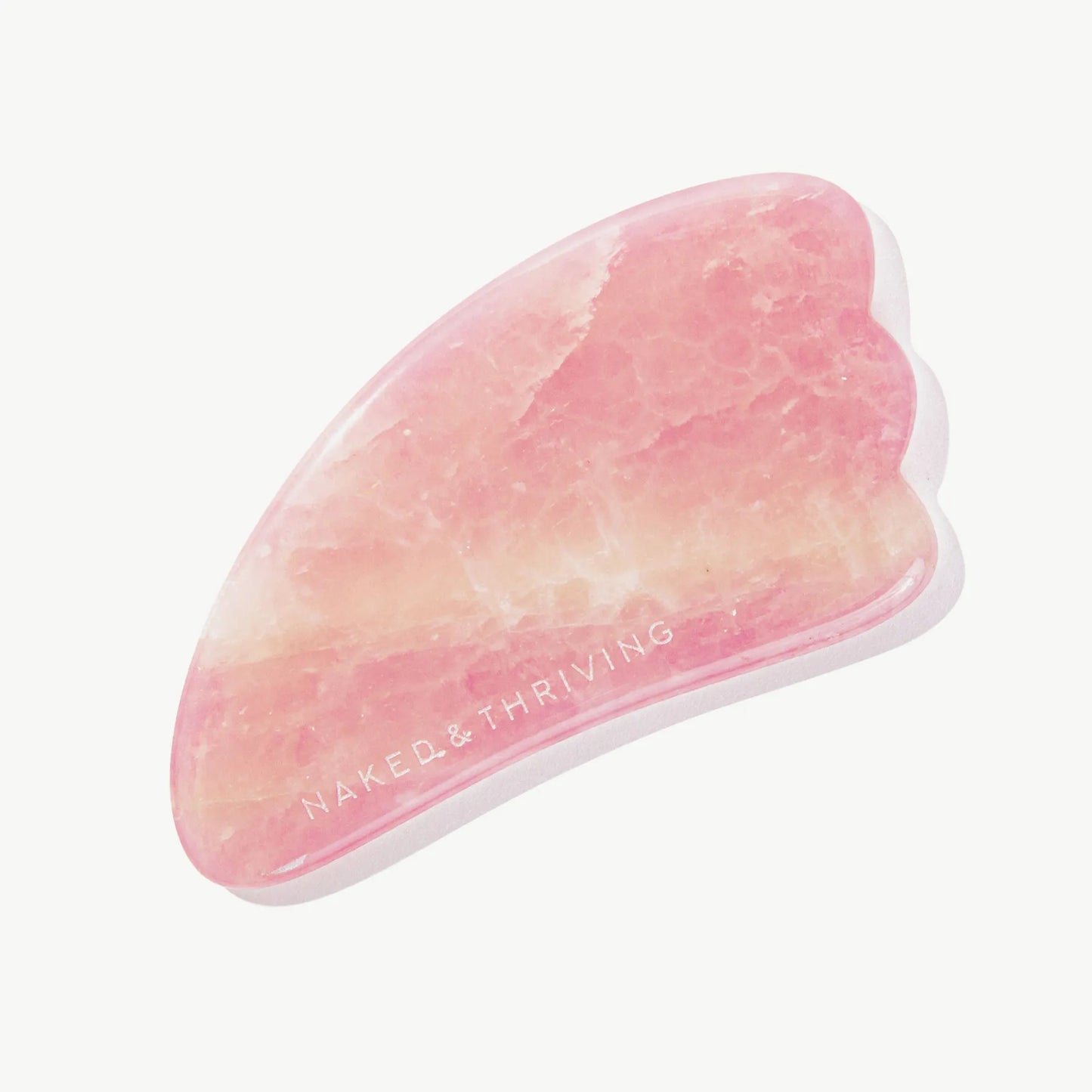 Polished pink gua sha stone engraved with brand name