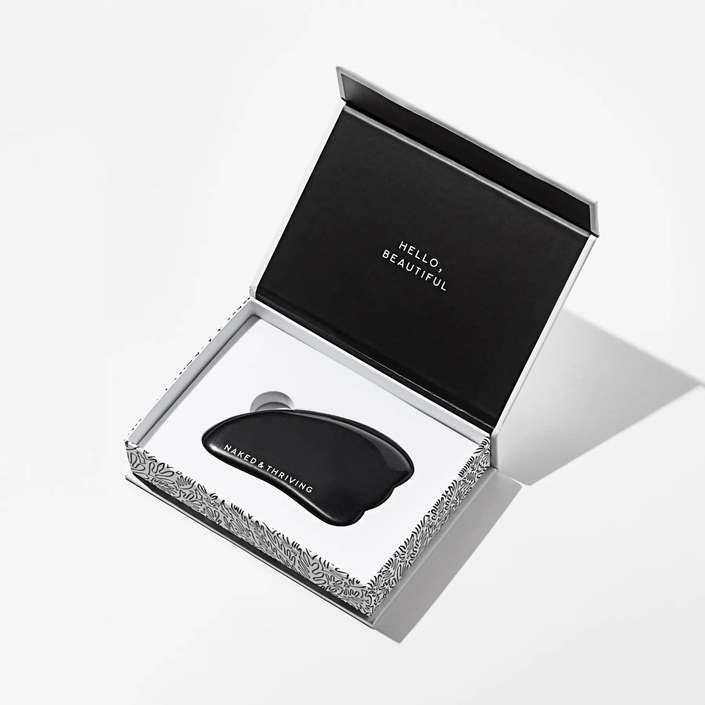 Polished black gua sha stone engraved with brand name