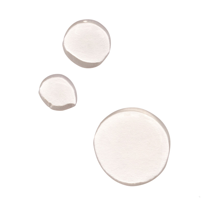 Close-up of clear serum droplets on a white background